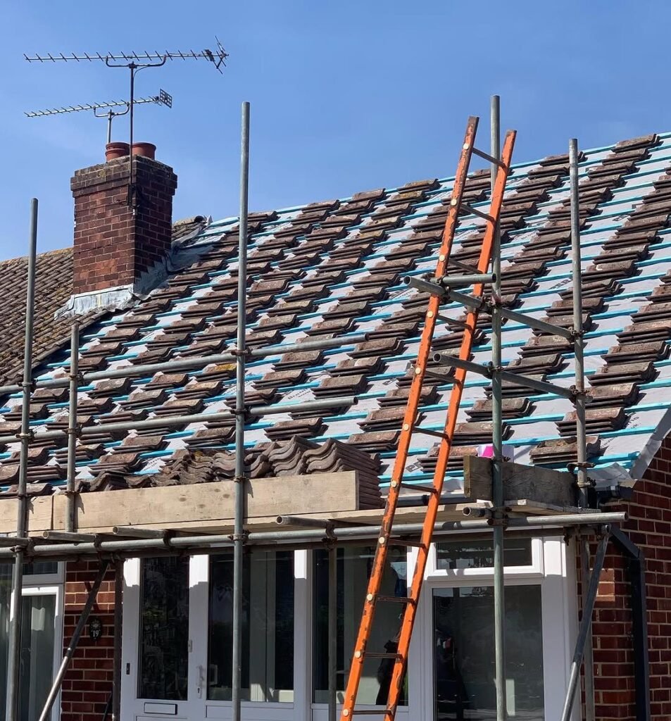 Old tiles stripped from a roof before a full re-roof in Worthing